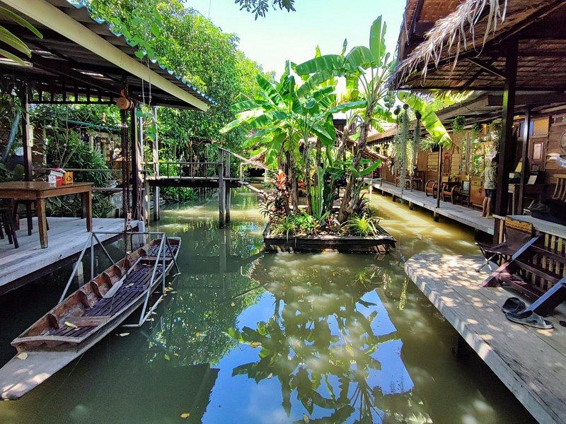Longtail boats moored along a quiet stretch of the Damnoen Saduak canal